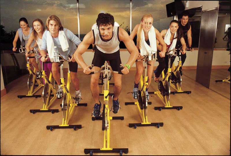 Un   Grupo   de  Personas  Jóvenes Haciendo Spinning en  un  Gimnasio