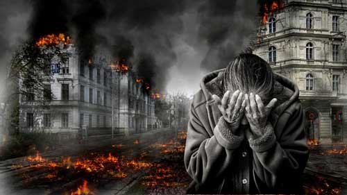 A woman covering her face in despair, with a scene of destruction behind her