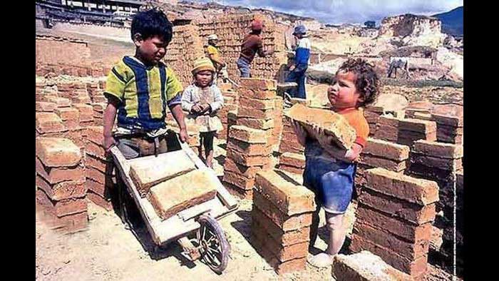 Tres niños muy niños trabajando como hacedores de ladrillos