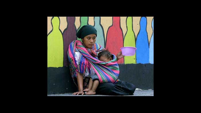 Young girl hugging her baby, while begging on the street